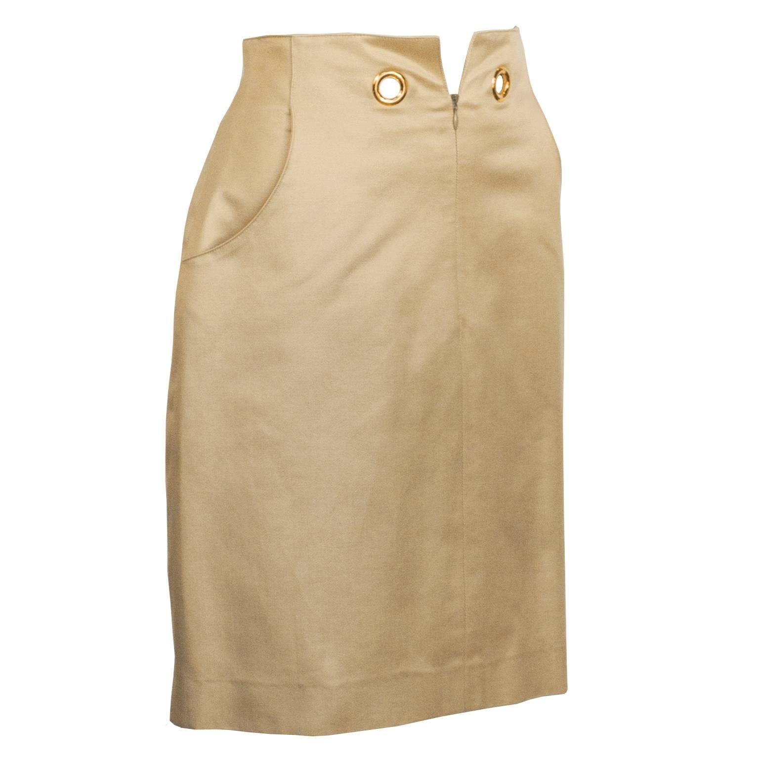 Chic 1990's Hermes beige cotton gabardine straight cut skirt featuring two gold grommets, two slit pockets, and a front zip closure. Fully lined in beige silk. Excellent vintage condition. Best accessory for this piece is an Hermes twilly tied