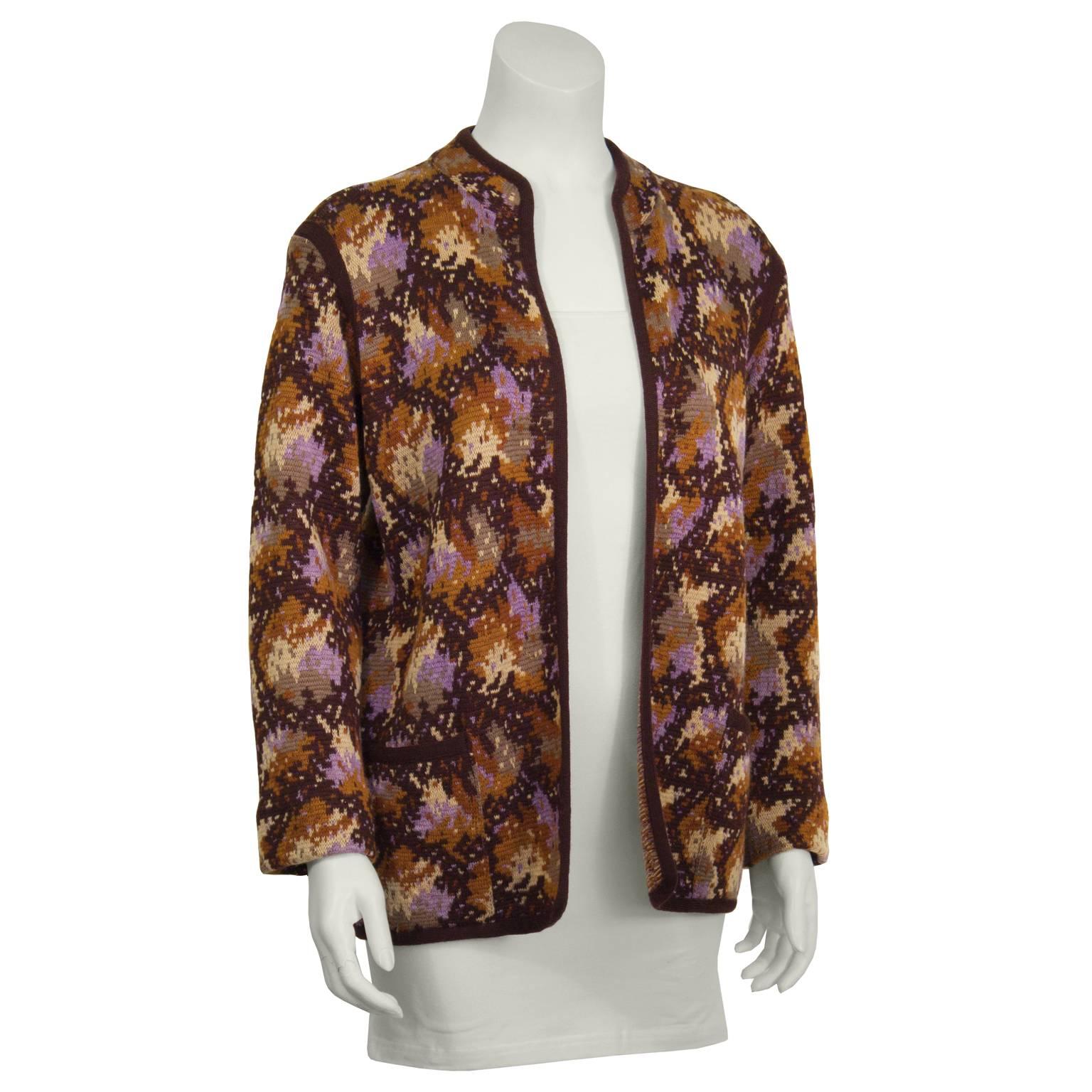 Mix comfort and style with this adorable Yves Saint Laurent brown and beige intarsia knit cardigan. Features a dark brown trim and a knit abstract pattern with notes of amber, beige, brown and purple. Excellent vintage condition. Fits like a US 4-6. 