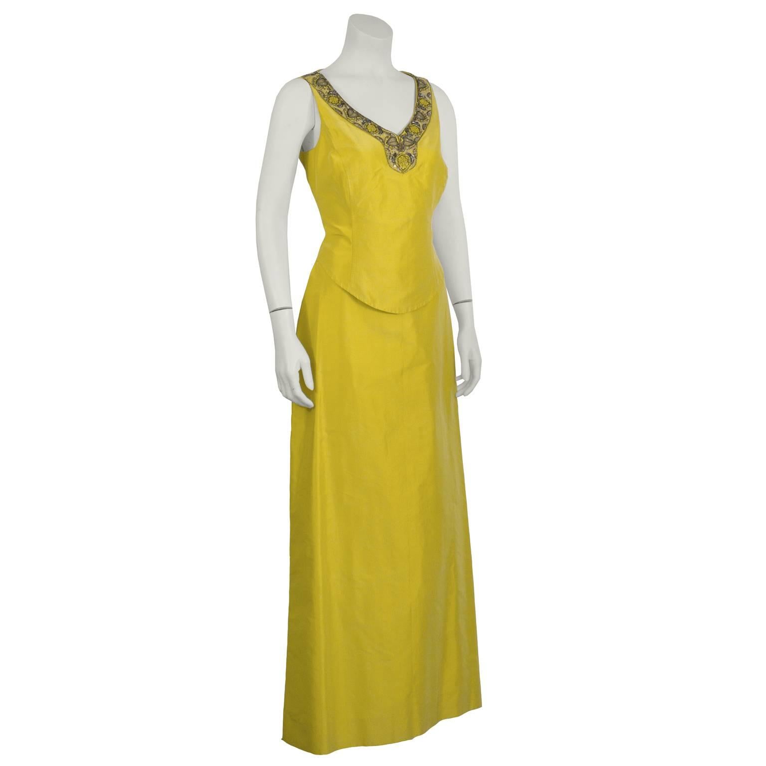 Carolina Herrera two-piece canary yellow silk evening ensemble from the early 2000's. V-neck fitted sleeveless top has intricate beaded detail around the neckline in yellow, silver, and pewter beads, and an invisible side zip. Full length a-line