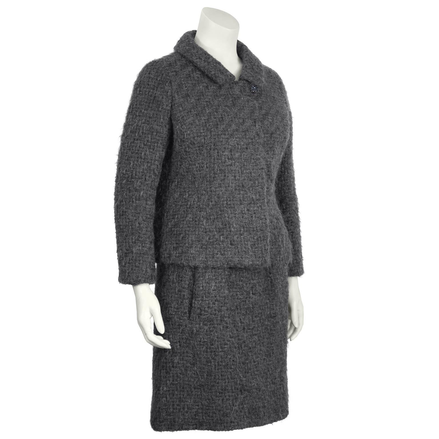 1960's Christian Dior exclusive design for Holt Renfrew Canada charcoal grey woven wool skirt suit. Box shape jacket has a pointed flat collar, with beaded grey button at the neck, and placket closure with hidden buttons. Skirt has a banded