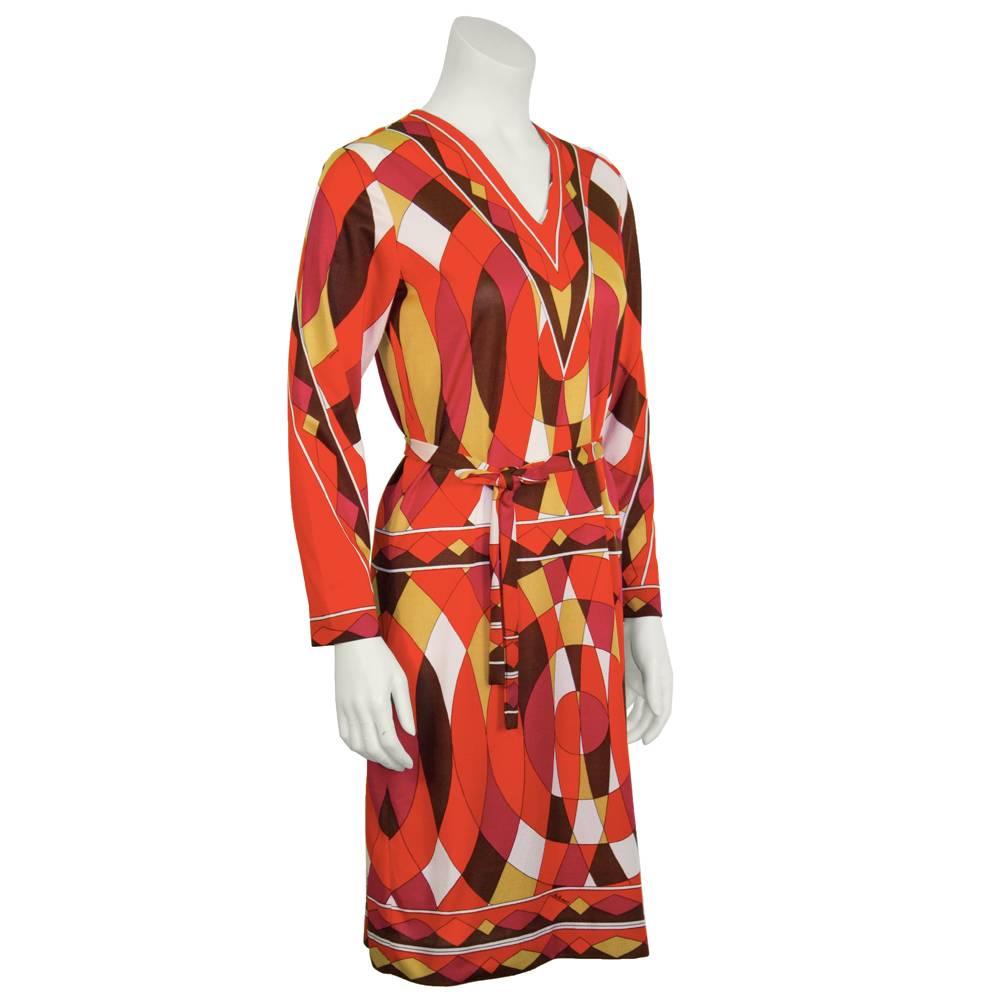 Artemis 1970s Pucci inspired day dress with an op art kaleidoscope print of red, orange, white, magenta, brown and olive. V neck, long sleeves, and an optional tie up waist belt. Back zip closure. Excellent, like new condition. Fits like a US 4.