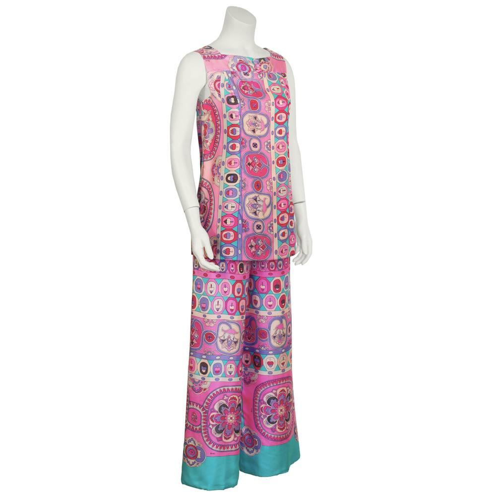 1970's Bessi tunic and pant set made of printed silk with a stunning blue and pink bohemian pattern from head to toe. Sleeveless tunic has a high square neckline, three fabric covered buttons at the center, and fastens with a back zipper. Cropped