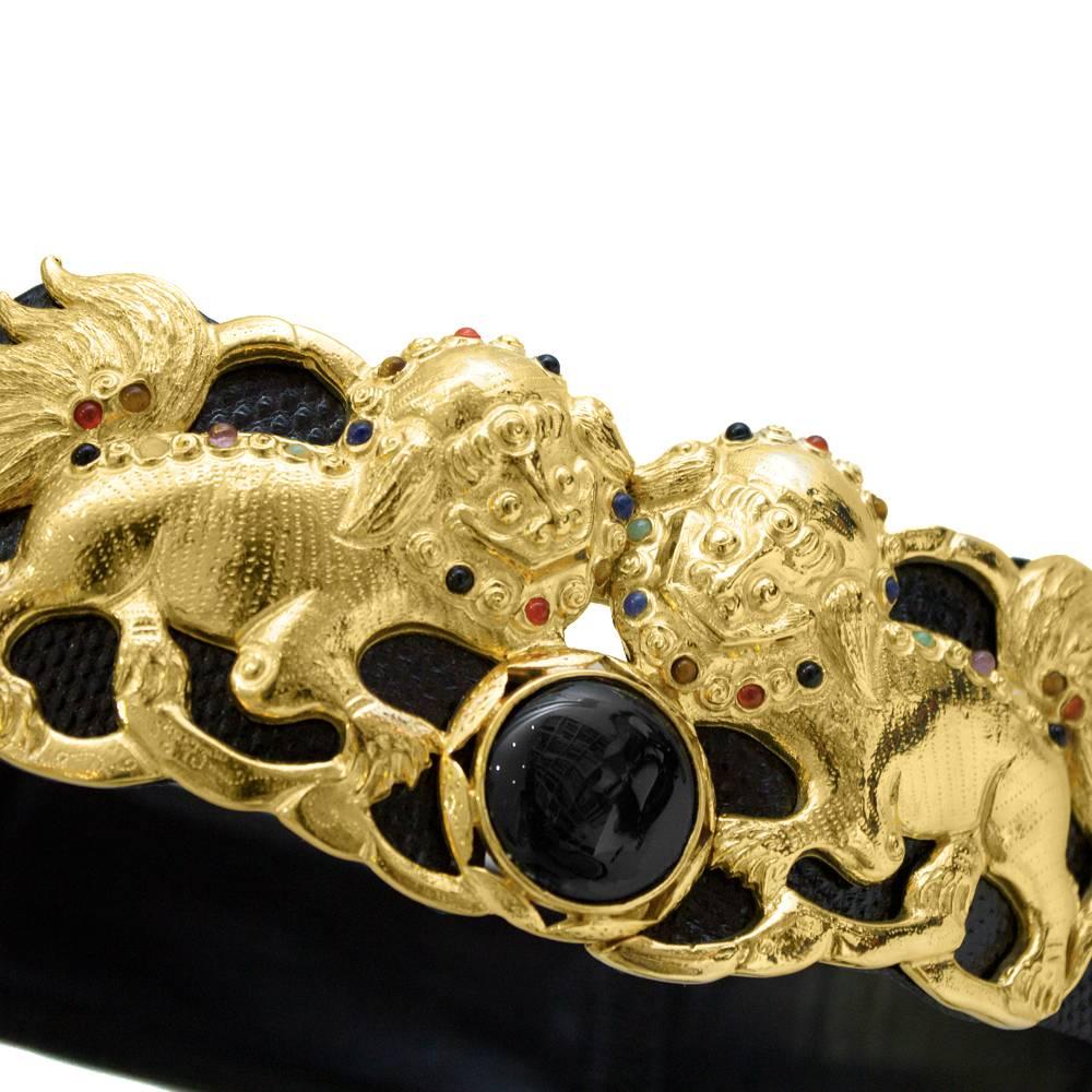 Judith Leiber 1980’s glossy wide black python belt with a spectacular gold buckle depicting two Chinese lions dotted with semi precious stones. Adjustable fit and fastens with a hook clasp. In excellent, almost unused condition. 
