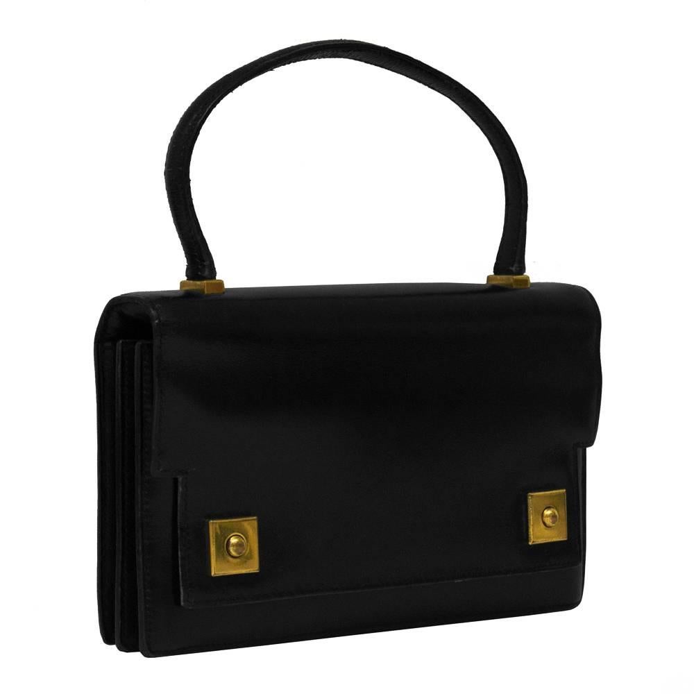 1950’s Hermes black box leather Piano bag with gold hardware. The accordion style bag has a front flap with a notched detail and gold plated square closures. A gentle pull on the front buckles reveals an interior with 2 large compartments. HERMES