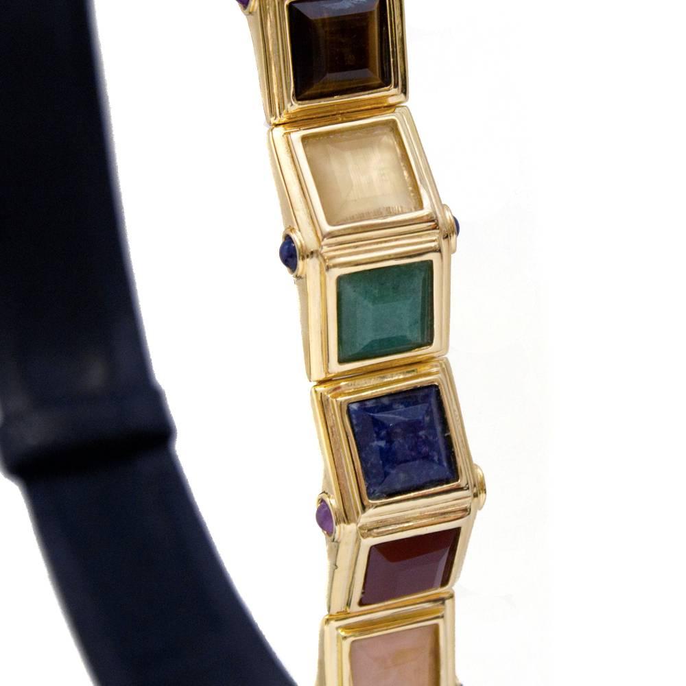 Amazing 1970’s Judith Leiber navy lizard belt with a beautiful multi-colored stone buckle. The buckle features 8 different colored large square stones; purple, tanzanite, yellow, jade, lapis, red, amethyst and black all set in gold hardware with