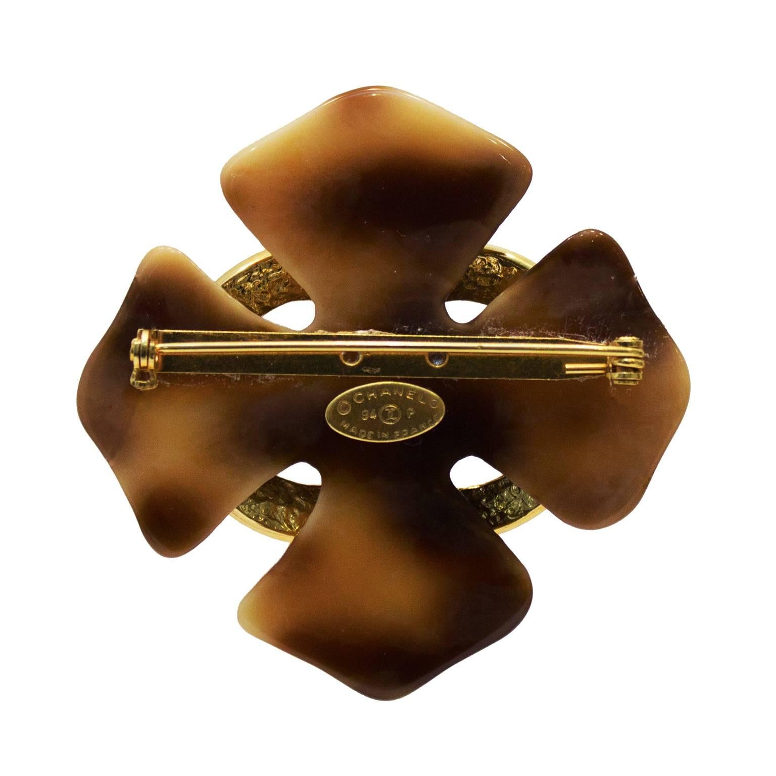 Chanel Spring 1994 cross shape pin. Made of faux tortoise shell highlighted with a large gold tone CC. Closes with a C clasp. In excellent condition. 