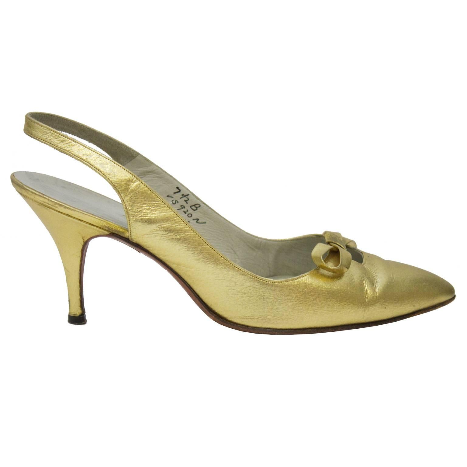 1950’s Roger Vivier gold leather pointed toe slingback heels. Shoe features a small cutout with a bow at the throat. Cream leather interior. Excellent vintage condition. Classic elegant style with moderate heel. Size US 7.5B  

Sole Length: 9.8