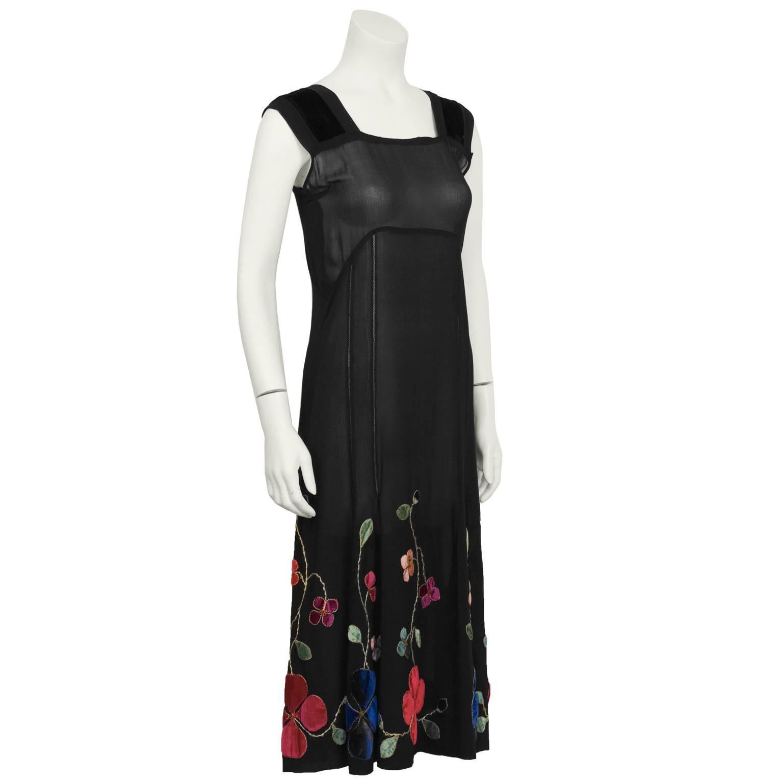 1930's black semi-sheer chiffon black tea/cocktail dress. The shift style dress has wide straps with velvet detail and lattice seaming down the front and back. The slightly flared skirt is embellished with hand sewn velvet floral embroidery in red,