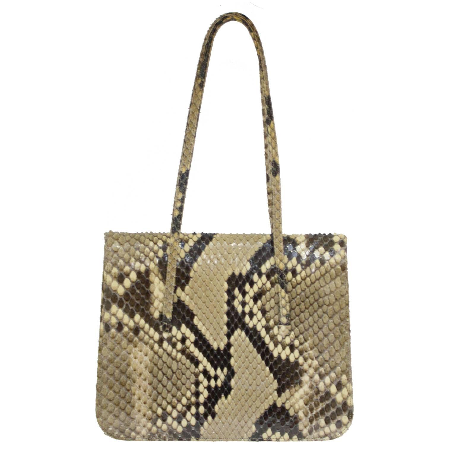 Judith Leiber python mini double handle handbag from the 1980's. Bag has two straps, and a mini flap that closes with a magnetic snap button. The interior has two pockets and is lined in beige grosgrain satin. Excellent condition. 