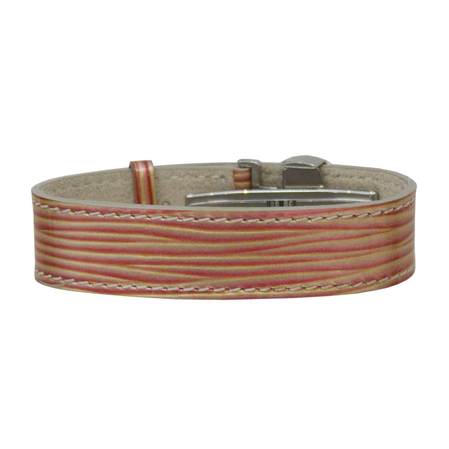 Louis Vuitton édition limitée millénaire cyber manchette. Le bracelet en cuir épi bronze et blush a une finition chatoyante et est lisse au toucher, presque comme du vernis. Orné de matériel argenté et d'un fermoir papillon caché.  Le bracelet a été