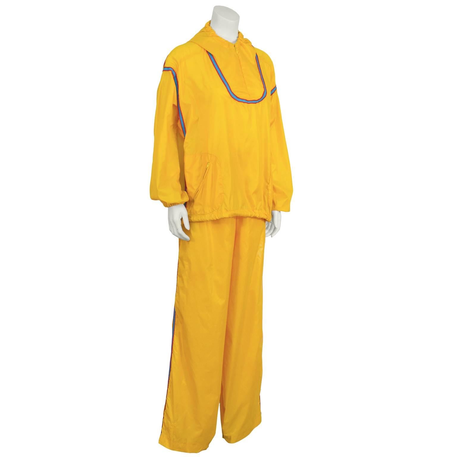 The Beene Bag by Geoffrey Beene canary yellow wind suit warm up outfit from the 1970's.. The zip neck jacket features diagonal zip pockets, and elasticized cuffs. The jacket can be tightened with the drawstring passing through silver grommets at