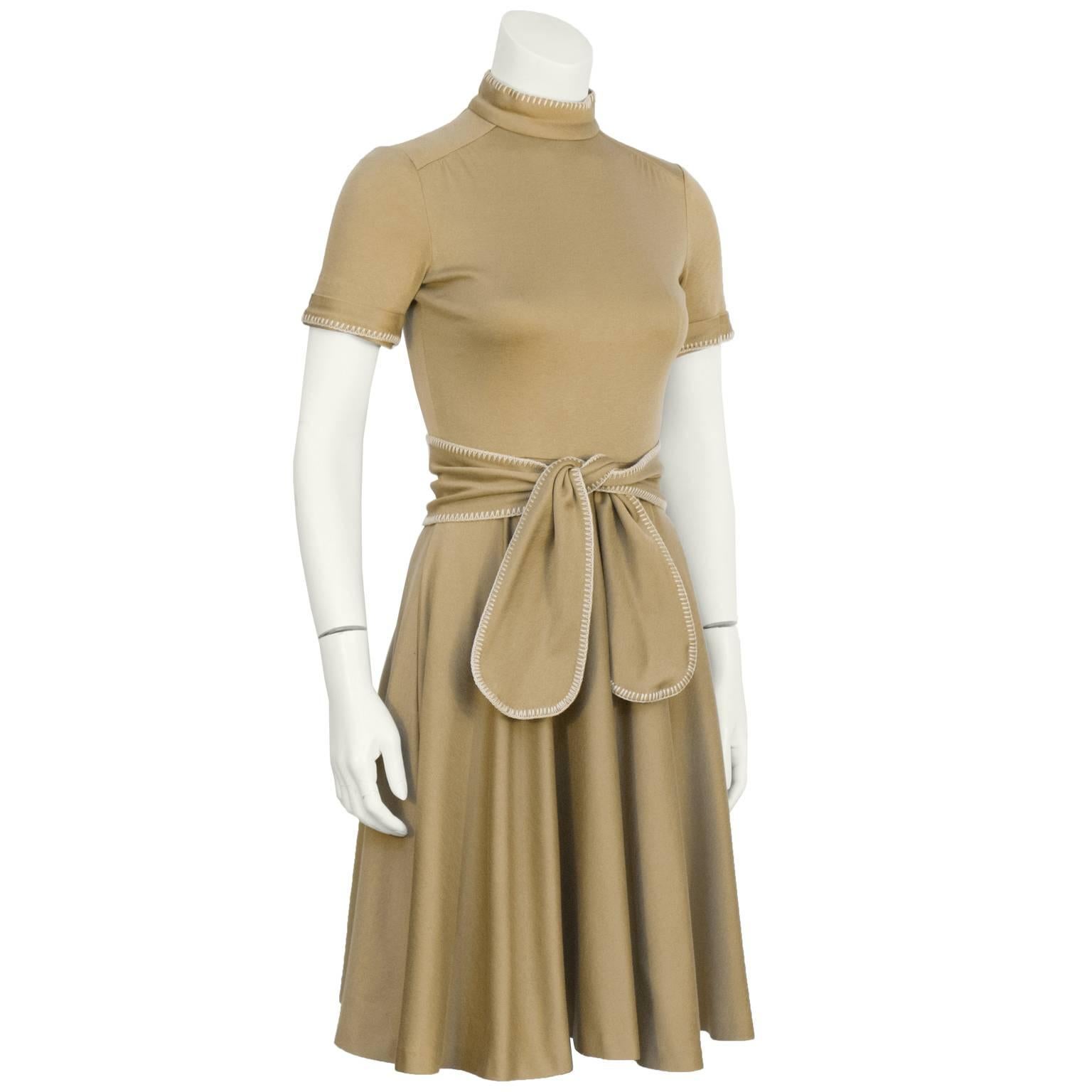 Geoffrey Beene 1970's brown cotton jersey mock turtleneck short sleeve dress with a circle skirt and matching belt. The dress features tonal whipstitch detail along the cuffs, neckline and belt. Zipper up the back and inseam pockets at the hips. In