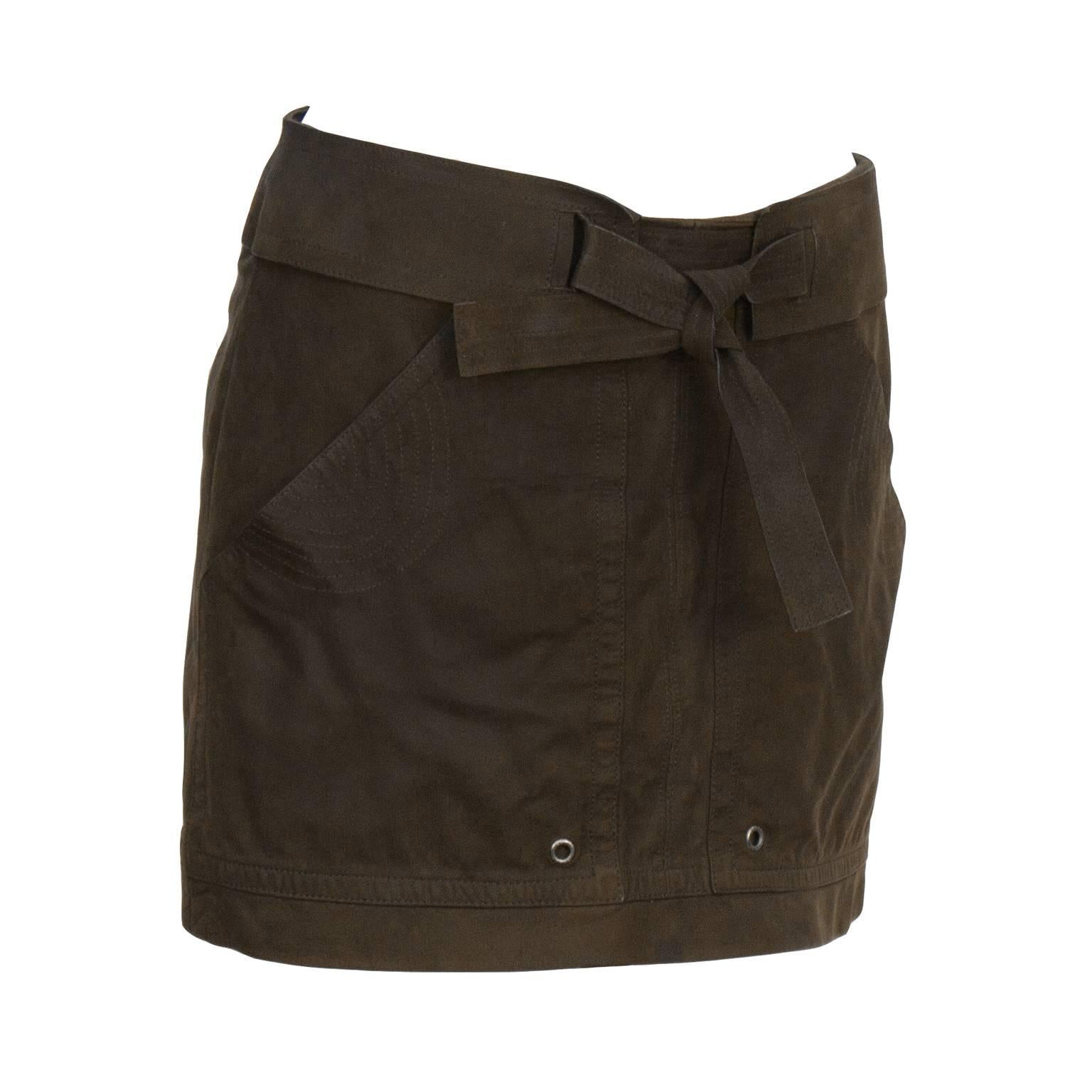 Gucci chocolate brown suede mini skirt from the late 1990’s - early 2000's. Cargo style with large front pockets, detailed with grommets and semi circle stitching. Attached belt ties at the front in matching suede tie. Hidden zipper on hip excellent