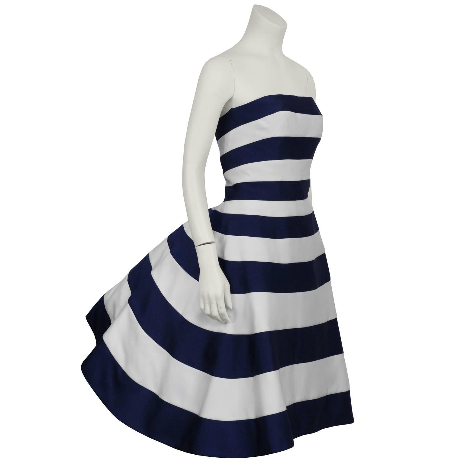 Victor Costa 1980's blue and white striped satin strapless cocktail dress. The dress is a classic Victor Costa style with a fitted front and exaggerated pouf at the back. The underskirt is cream satin, pencil style and finished with a navy banded