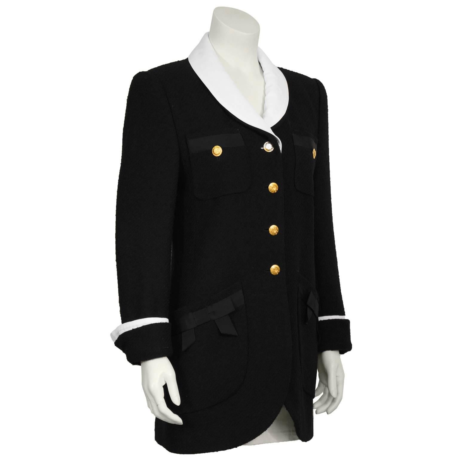 Rena Lange black boucle Chanel style blazer from the late 1980's. The jacket has a white cotton pique removable lapel and cuff detail and is adorned with logo gold buttons down the front and on the cuffs. The breast pockets feature two buttons with