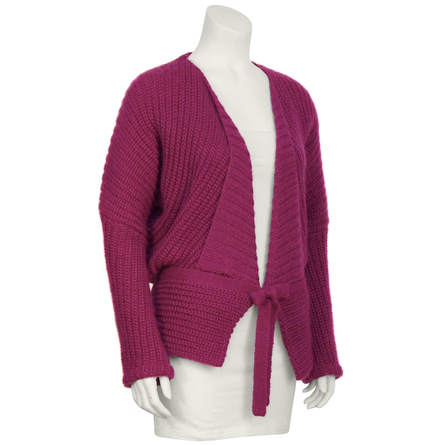 1980's Missoni fuschia wool/nylon oversized shawl style knit sweater with a drop shoulder. The lapel is stitched into place which helps it hold its shape and the sweater comes with an additional matching belt/scarf piece. In excellent condition.