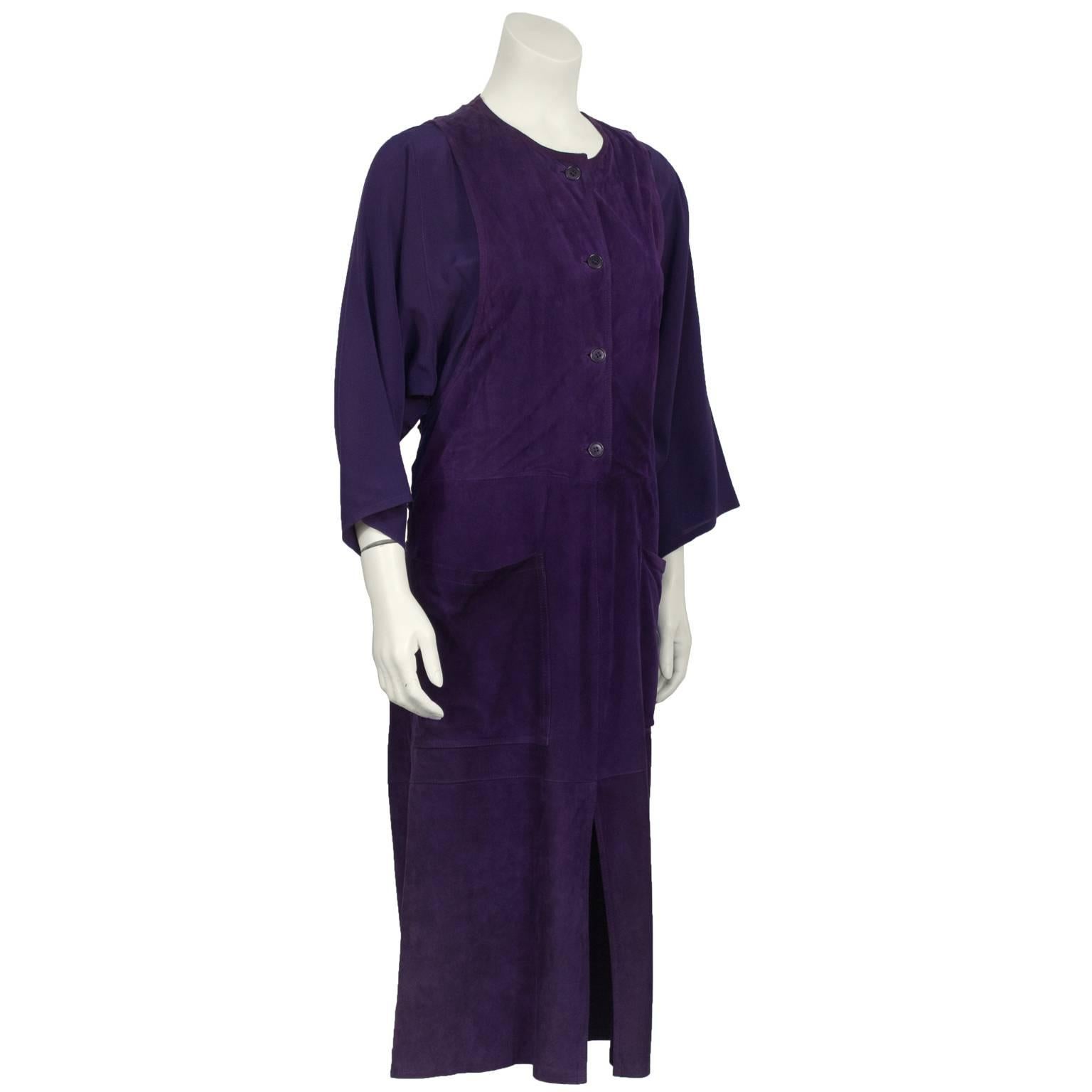 Anonymous plum suede and rayon crepe dress from the 1970's. Possibly designed by Jean Muir. The dress gives the illusion of wearing a dolman sleeve blouse underneath a suede jumper with buttons down the front, a front slit and oversized front