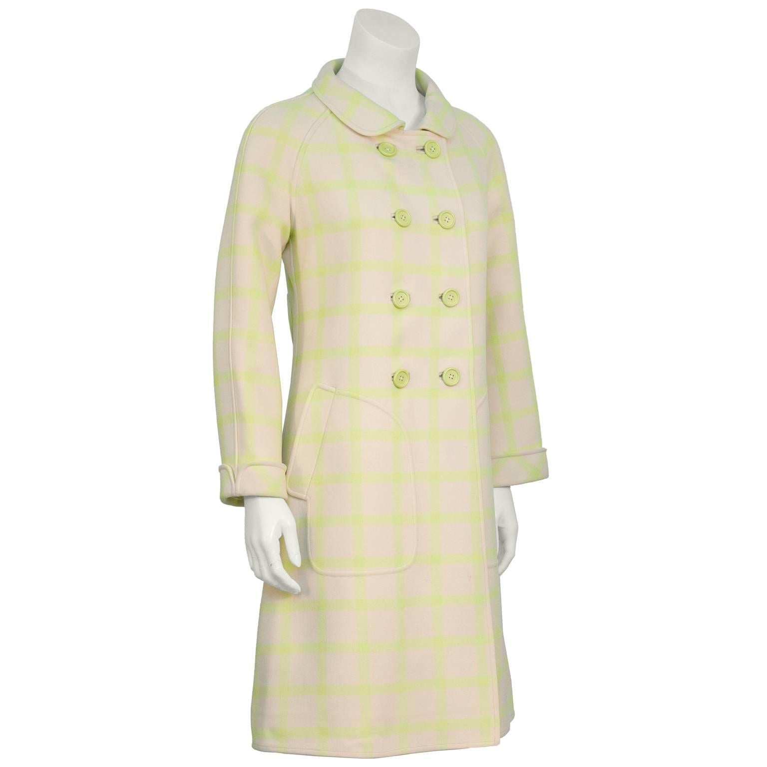 Couture Courreges 1960's beige and lime green wool double breasted coat with a windowpane pattern. The coat features a Peter Pan collar, stitched cargo flap pockets at the hips, and matching lime green buttons up the front. The back is finished with