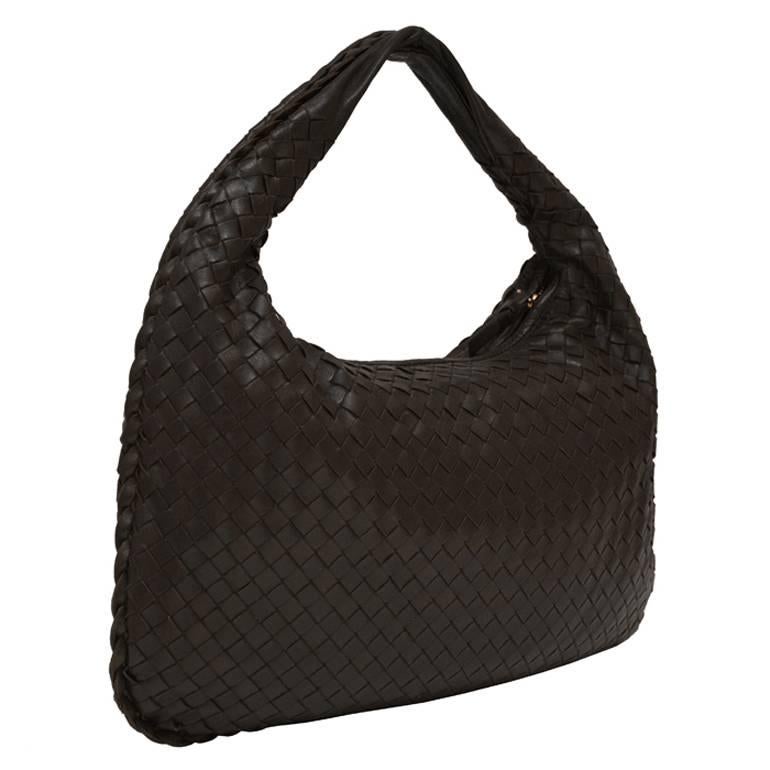 Bottega Veneta medium sized Intrecciato hobo bag in dark brown leather. The supple woven leather bag has a top zip closure and braided edge. The interior is lined in a beige suede and features one zipper pocket that is trimmed in matching brown