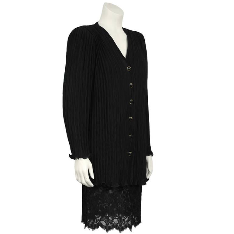 Emanuel Ungaro black evening skirt suit from the late 1980's. The long black Fortuny style pleated jacket features a lettuce hem and cuffs that zip. The black cabochon buttons down the front are trimmed in gold. The skirt features a lace panel at