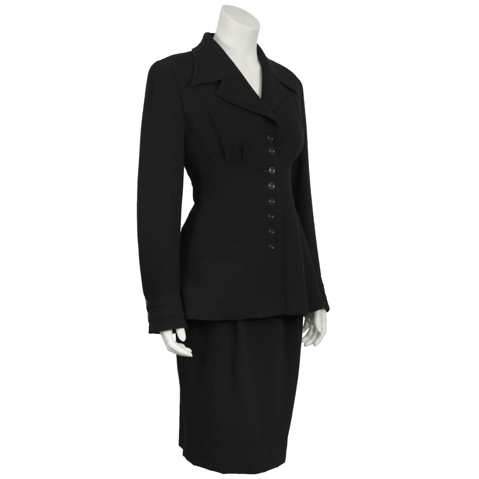 Karl Lagerfeld black wool suit from the 1980's. The feminine style jacket features slight gathering at bust and a multiple band detail along the waist creating a flattering silhouette. Black buttons down the front and on the cuffs also feature the