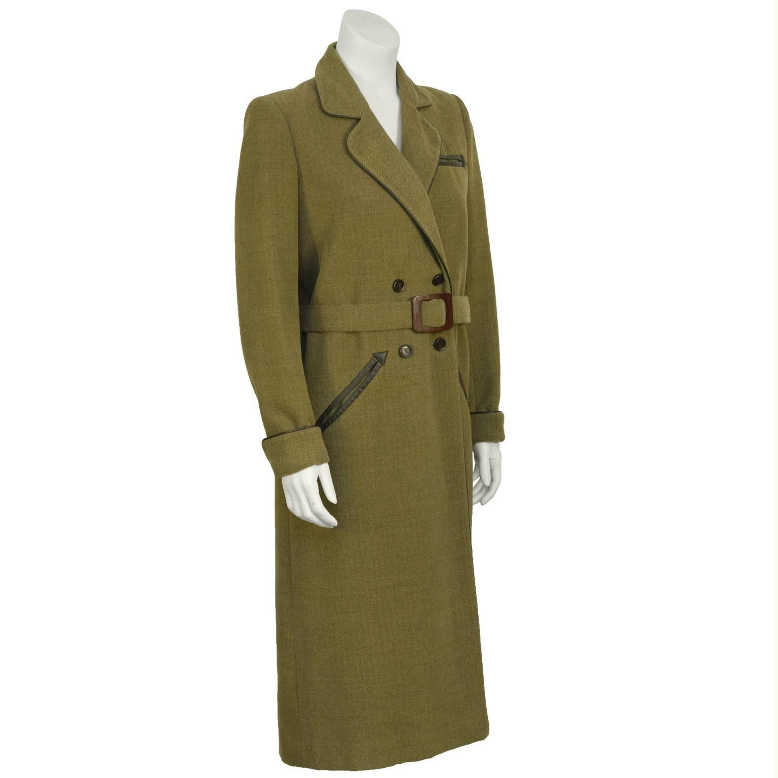 Jean Louis Scherrer double breasted belted army green wool maxi coat from the 1960's. The coat features a notched collar with leather piping. The piping detail continues on the cuffs, the edges and on the diagonal welt pockets at the hips and breast