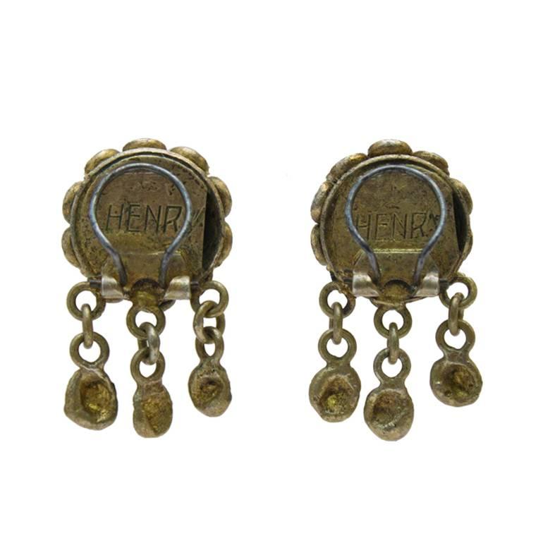 1950's French gilt bronze and blue tigers eye earrings. The romantic clip on earrings feature royal blue and green tigers eye center, surrounded by green glass beads with three hand forged gilded bronze hanging charms. Signed 