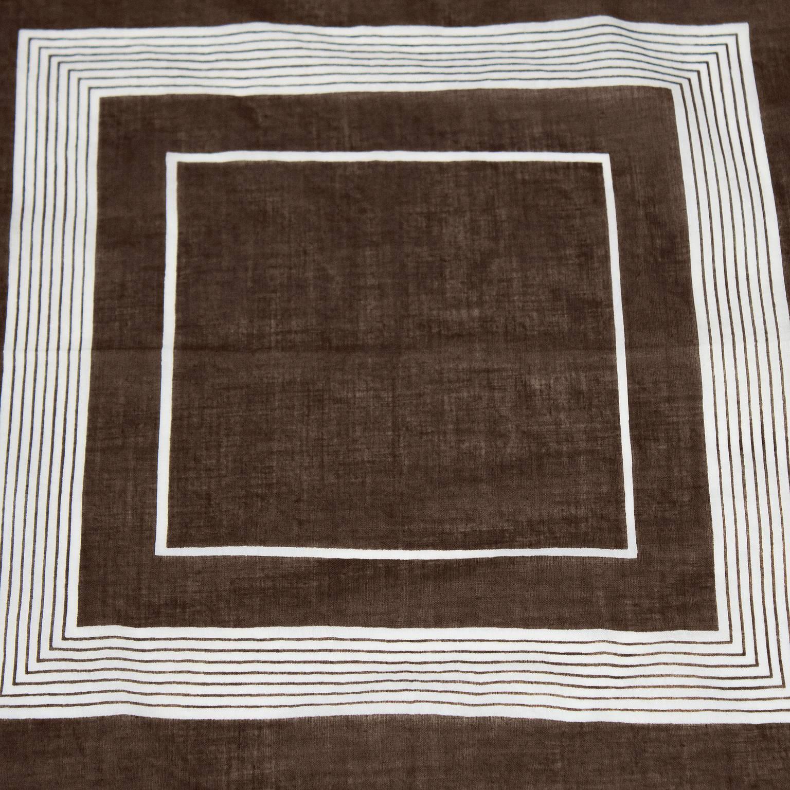 Unisex styled brown and cream cotton square scarf by Yves Saint Laurent from the 1970's. The scarf features geometric cream squares on a brown background. In excellent condition. Signed Yves Saint Laurent on the corner. Measures 25