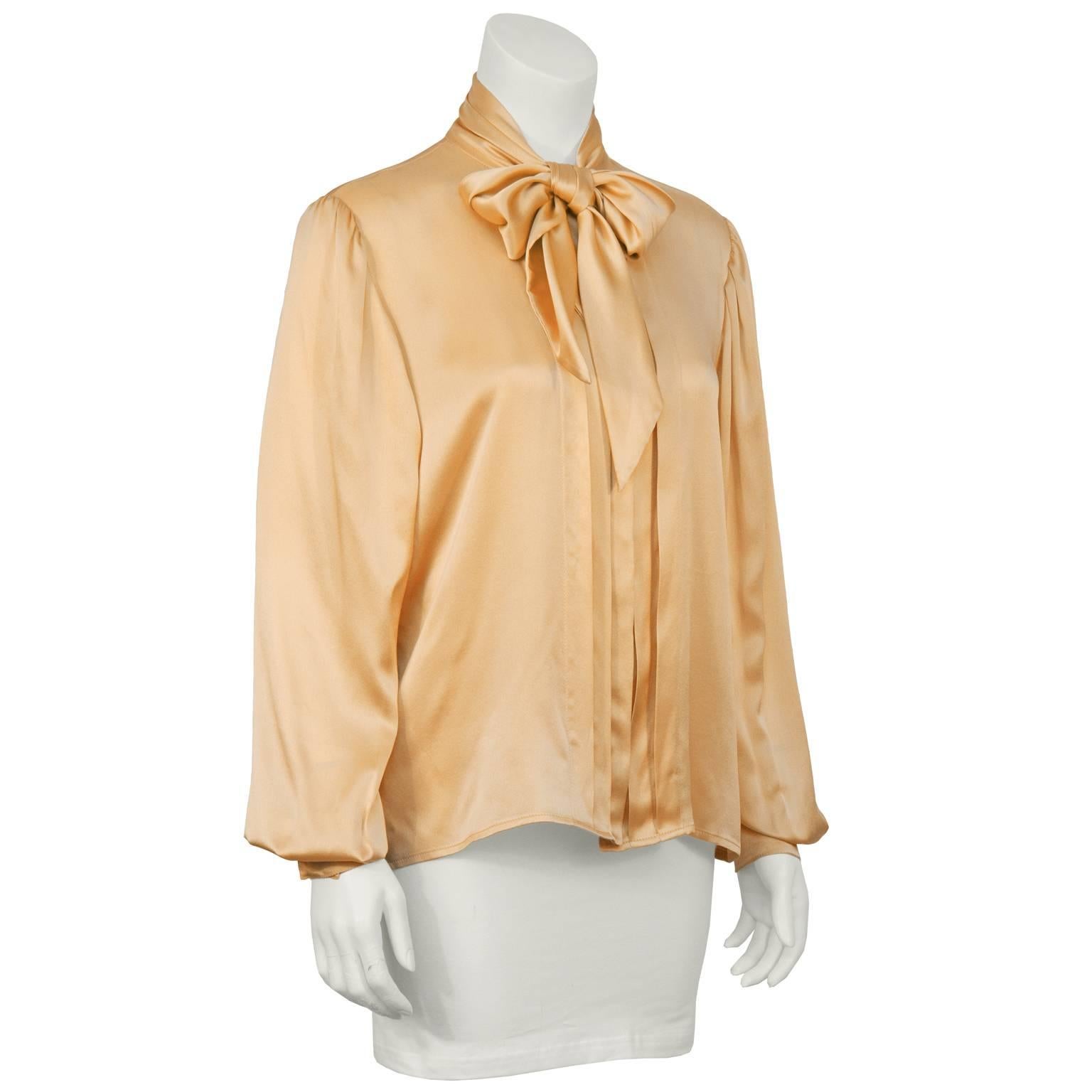 Ungaro Parallele blush peach silk necktie blouse from the 1980's. Features a pleated placket down the front hiding buttons, finished with a self tie bow at the neck. The cuffed sleeves feature faux mother of pearl buttons and there is a single box