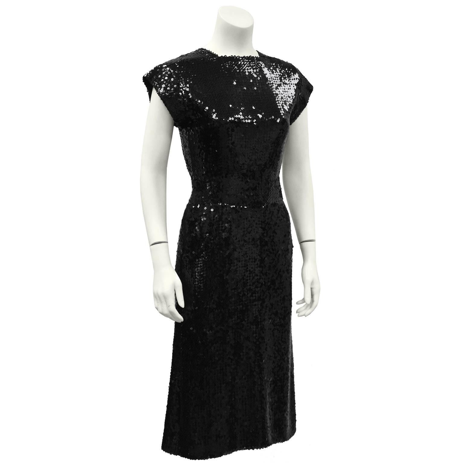 1970's Ungaro jet black sequined cocktail dress and jacket. The jacket fastens at the natural waist with a hook and rhinestone button. Tuxedo-style shawl style lapel. The dress features a high neckline, capped sleeve, wide inset banded waist and