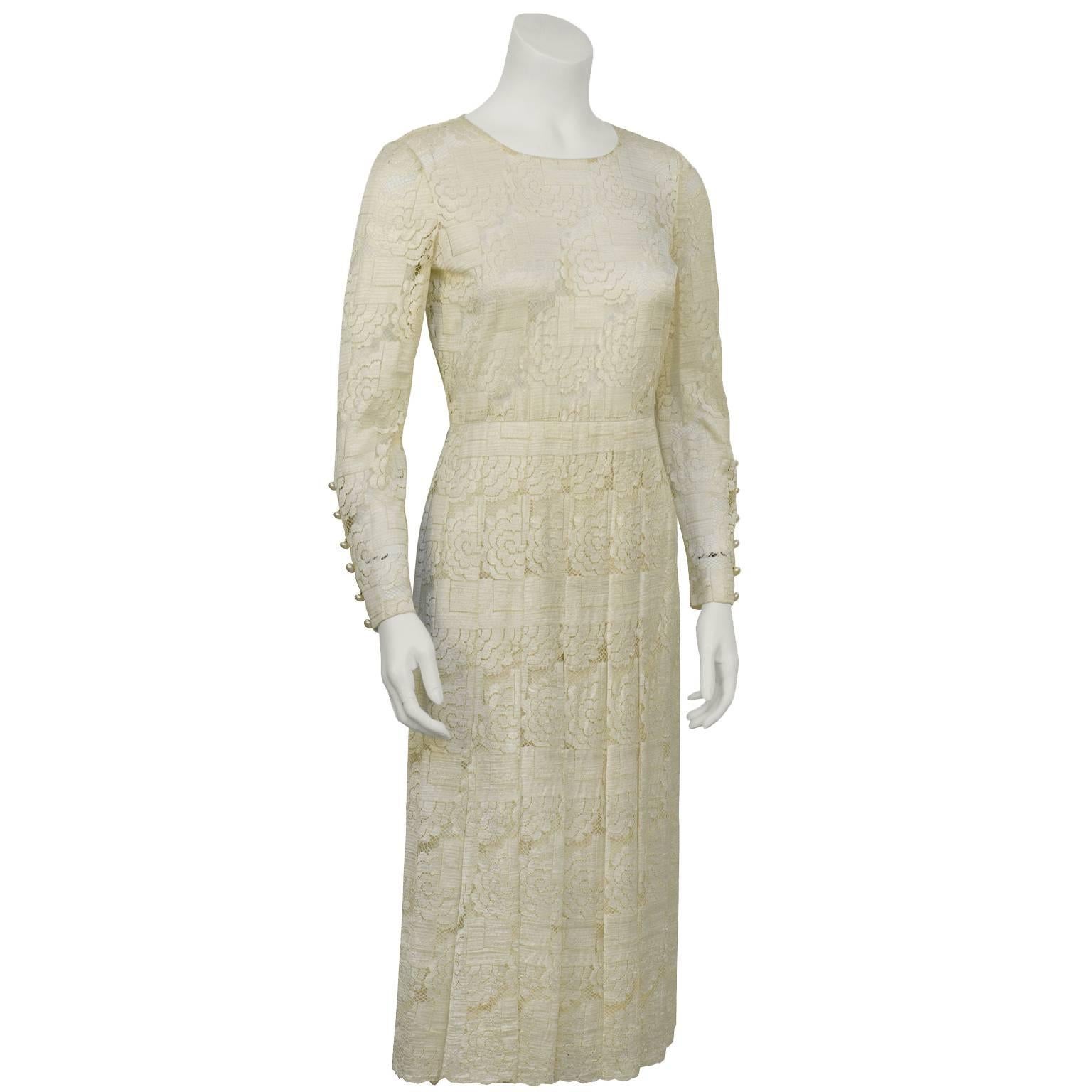 1960's tea length cream lace dress attributed to Dior, label missing however provenance is from a well known Dior client  in Canada. Round neckline, long sleeves finished with off white pearl buttons, fitted through the waist with stitched box