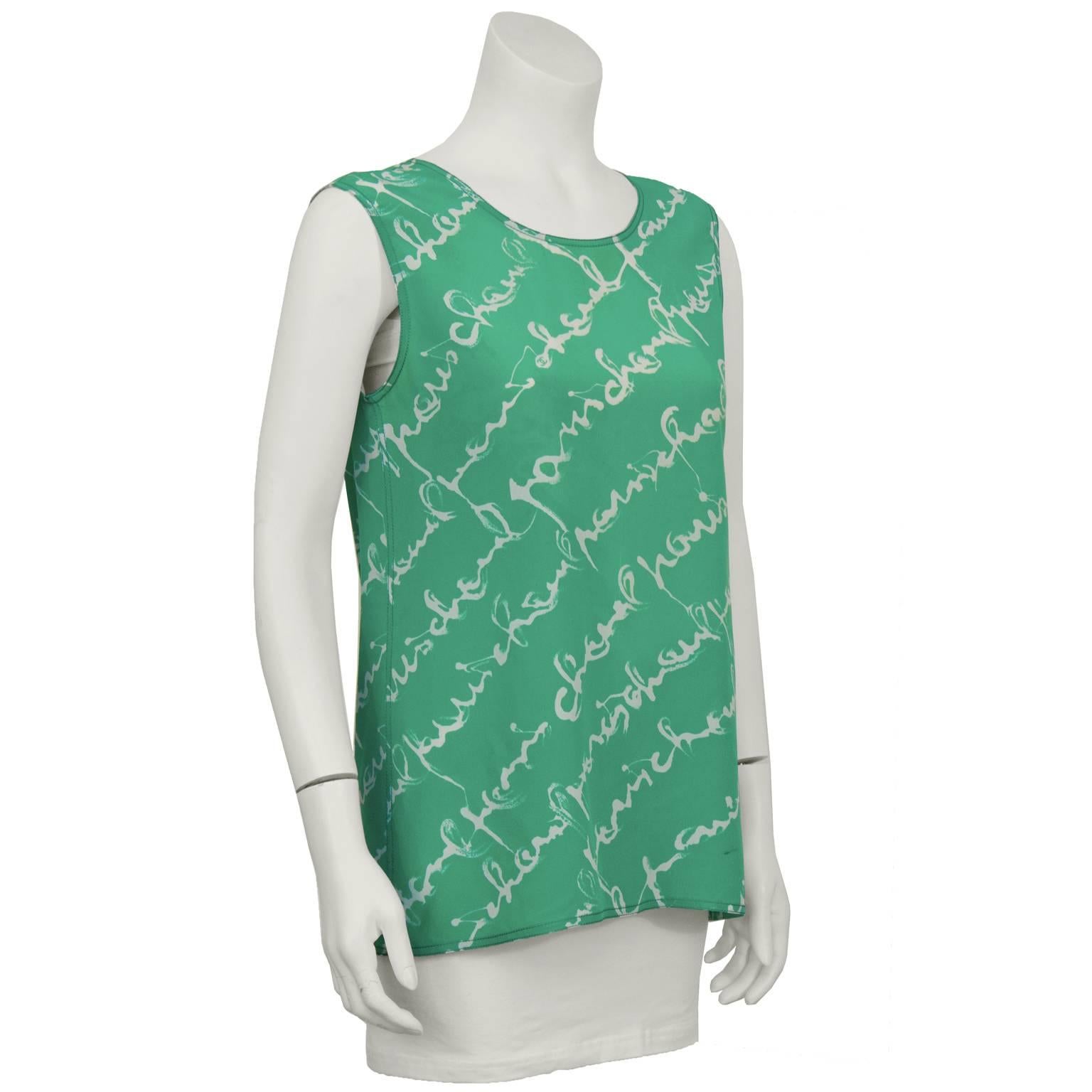 Late 1980's bright green sleeveless silk tank features an all over diagonal print with handwritten “Chanel Paris”. Two gold-tone CC buttons at the back of the neck. Excellent condition. Fits a US 4-6.  
