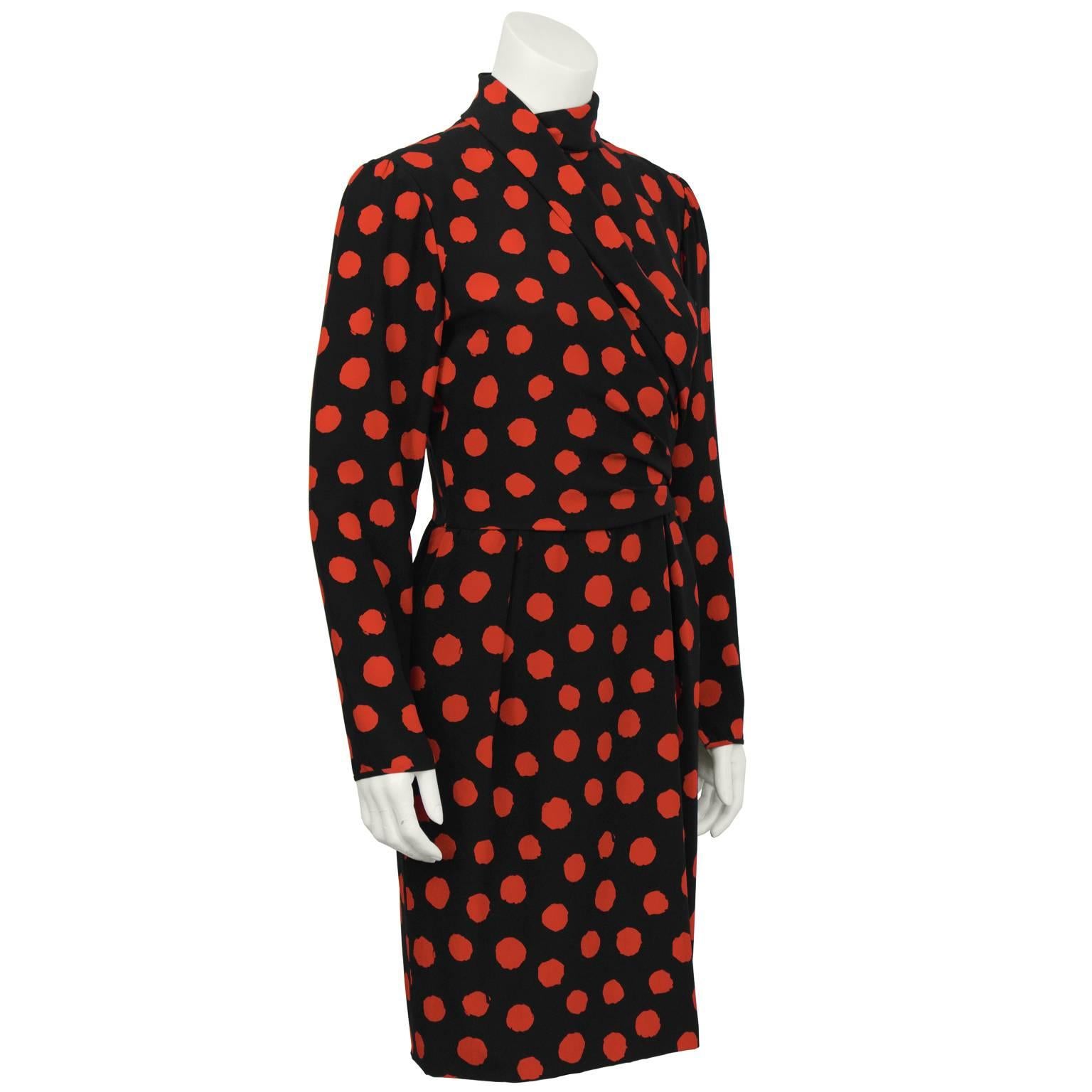 This black and red silk Ungaro day/dinner dress from the 1980's has a unique folded high collar that continues to a faux overlapping wrap detail across the front and gathers at the side. Sleeve finishes with zipper at the cuff, the skirt has inseam