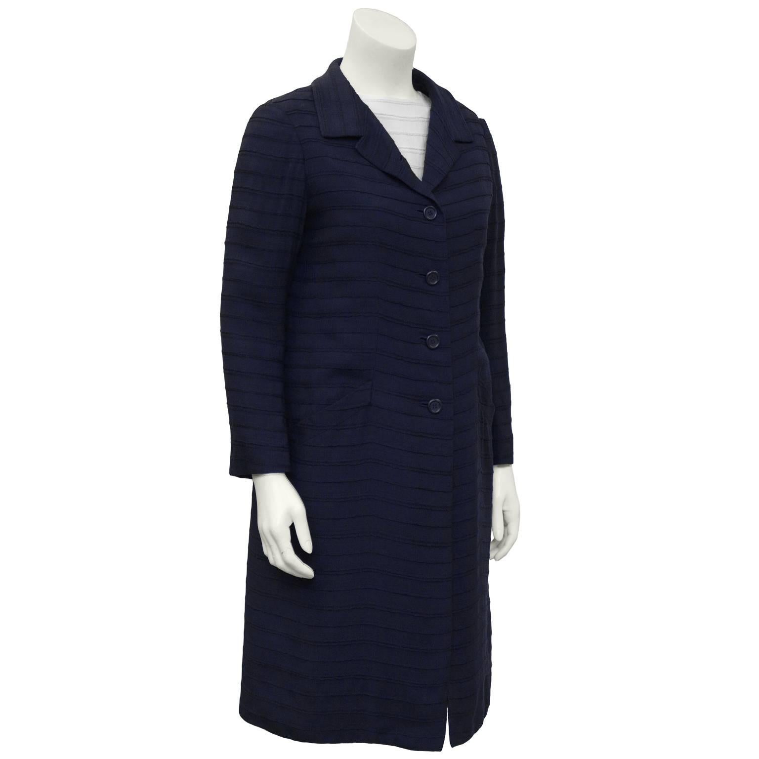 1960's horizontal textured cotton dress and coat ensemble. White sleeveless drop waist, zip-back, Jackie-O style dress complimented by navy single-breasted notch collar coat. Angled slit hip level pockets on the coat, five buttons, yoke back, slight