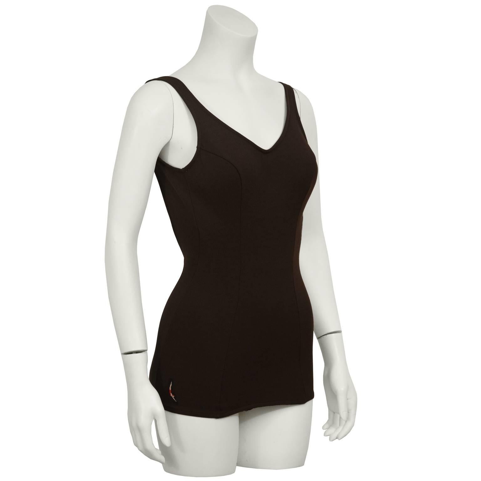 Classic Jantzen brown one-piece stretch polyester bathing suit from the late 1960's. Features a sewn in bra with cups and a low back, seams down the front. Finished with a Jantzen diving girl logo patch on the left hip. Elastic and synthetic fabric