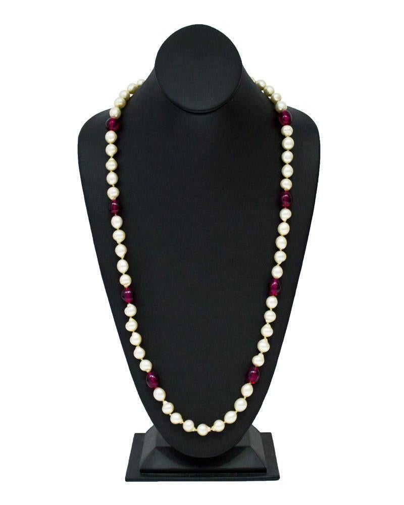 Long pearl necklace with eight red poured glass beads from the 1960's. The finish on the faux pearls is in impeccable condition. The necklace is long enough to double up and wear as a two strand piece. Rhinestone embellished fish-hook closure. 