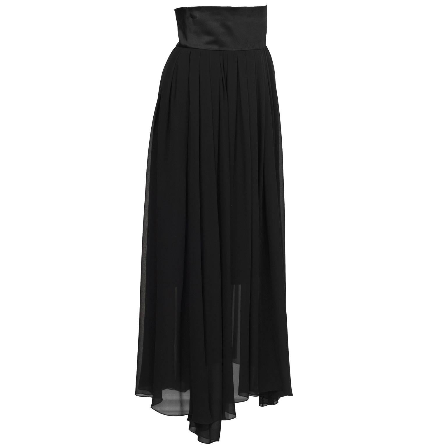 Chanel 1980's black crinkle chiffon and satin evening skirt. The skirt is composed of two layers, the bottom one hits at below the knee and is pencil skirt style, while the over skirt is loosely gathered and flows to the ground. Finished with a wide
