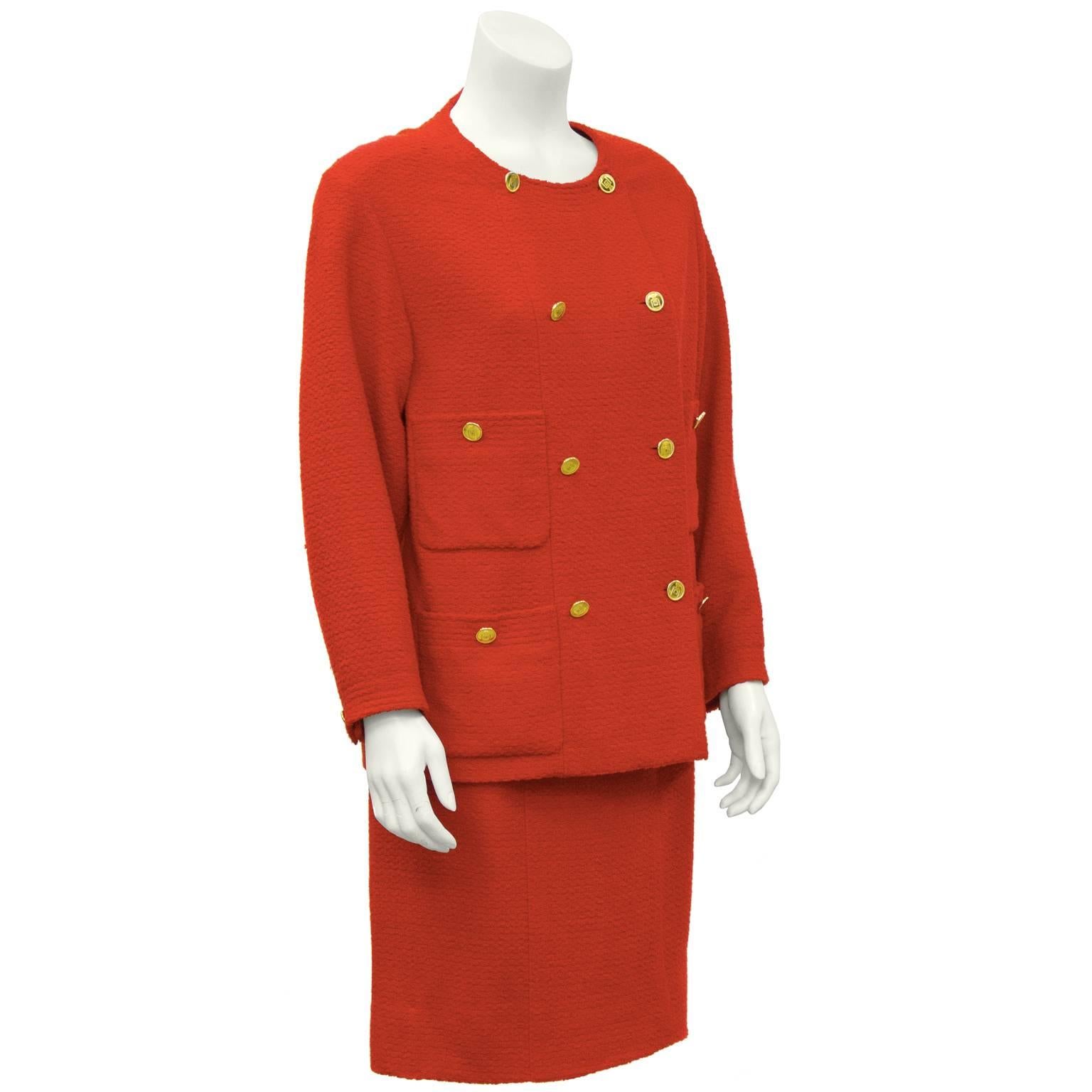 Chanel red boucle 1980’s panel front skirt suit. Jacket has four front pockets and does up the front with gold Chanel buttons featuring the iconic Chanel perfume bottle. Matching buttons on the cuffs. The matching red skirt zips up the back and has
