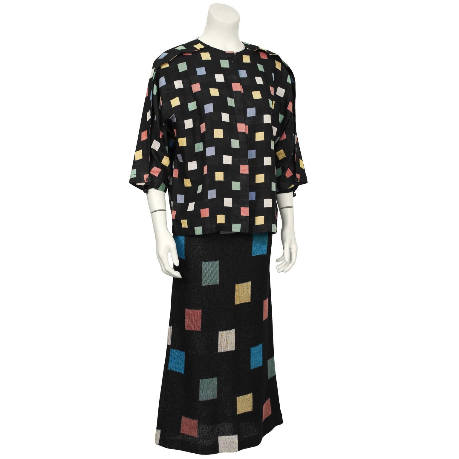 Missoni early 1970’s cotton knit maxi dress and cropped linen jacket ensemble. Both pieces feature an all over multicolored square print on a black background. The linen collarless jacket has an unusual top pleat down the arm that finishes with a