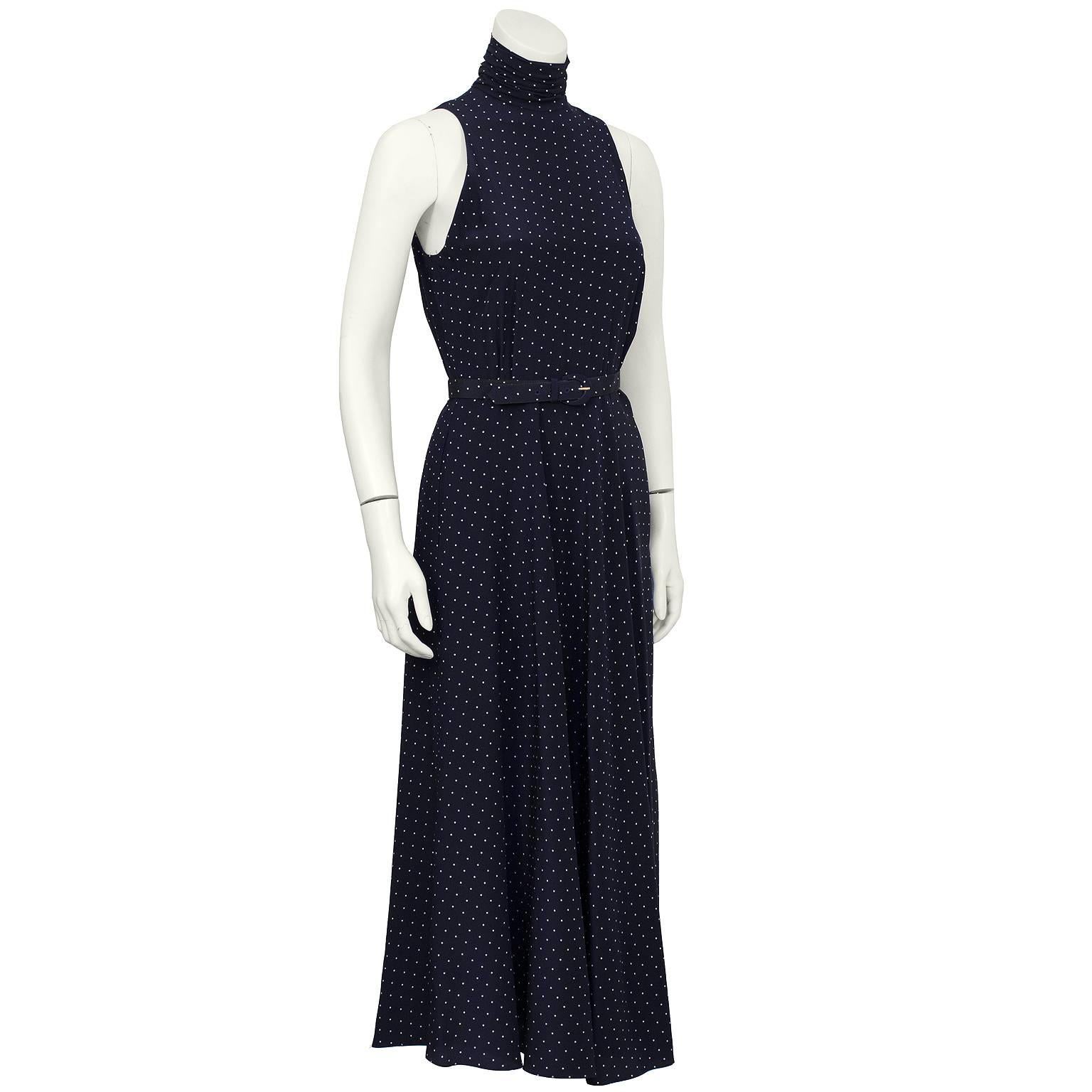 Silk navy polkadot belted maxi dress from the 1970s. The dress features a folded collar that fastens at the back with buttons and a matching belt to be worn at the natural waist. Finished with inseam pockets at the hips. In excellent condition. Fits