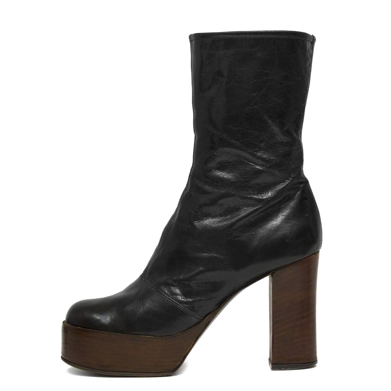 1970’s black leather platform boots from the Carnaby St. Beatles era. These boots sit mid calf height. Black leather body with an instep zipper closure and seaming down the front and across the bridge of the foot. Brown wood laminate stacked heel
