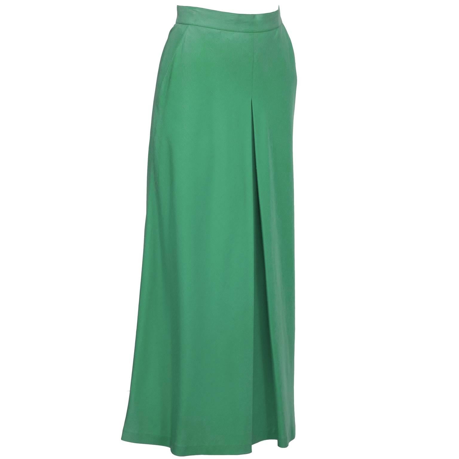 Chanel leaf green single pleat silk maxi skirt circa 1980's. Narrow side button waist band over side zipper finished with a single gold button. Single center pleat and soft triangular sweep and 2 silk lined pockets make this faux culotte maxi skirt