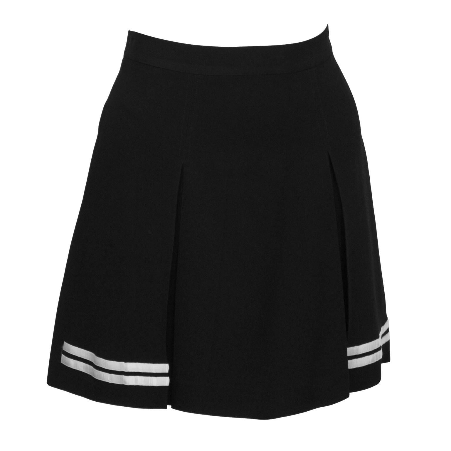 Adorable black Dolce and Gabbana acetate and rayon mini skort with saucy double kick pleat sand white stripe details. Perfect for your early morning walk  or a visit to the beach club. In excellent condition. Fits like a US size 4. Dry cleaned and
