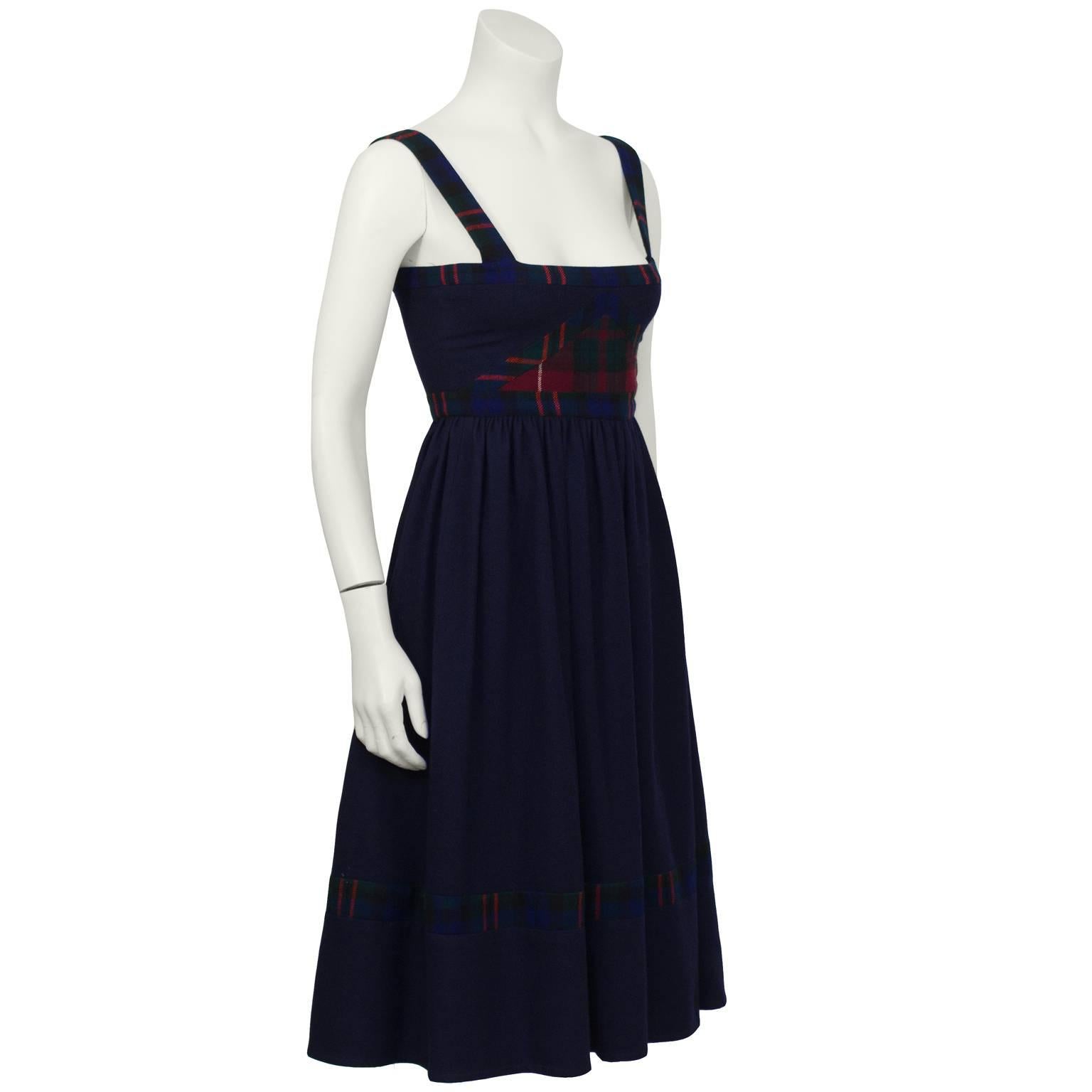 Anonymous navy and plaid wool jumper from the 1970’s. The jumper has wide plaid shoulder straps and a fitted bodice featuring a triangular plaid detail. The full skirt is slightly pleated at the natural waist, falls to the midi length and is