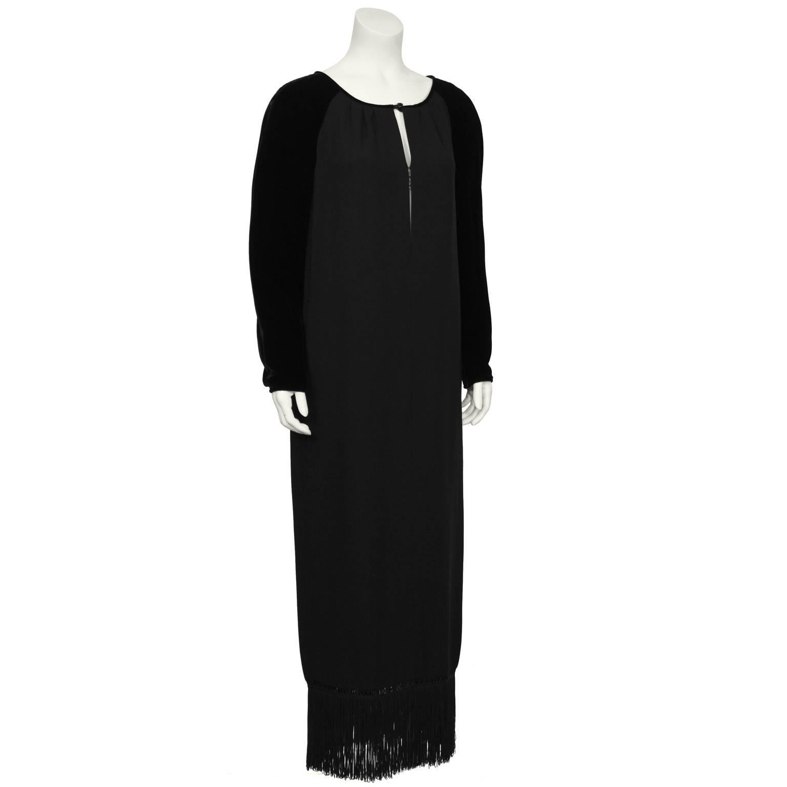 Gorgeous black velvet and crepe Valentino gown from the 1980’s. The gown has a slit neckline that fastens at the center with invisible hooks and a faceted black jet button. The neckline is piped in black velvet that blends into the black velvet
