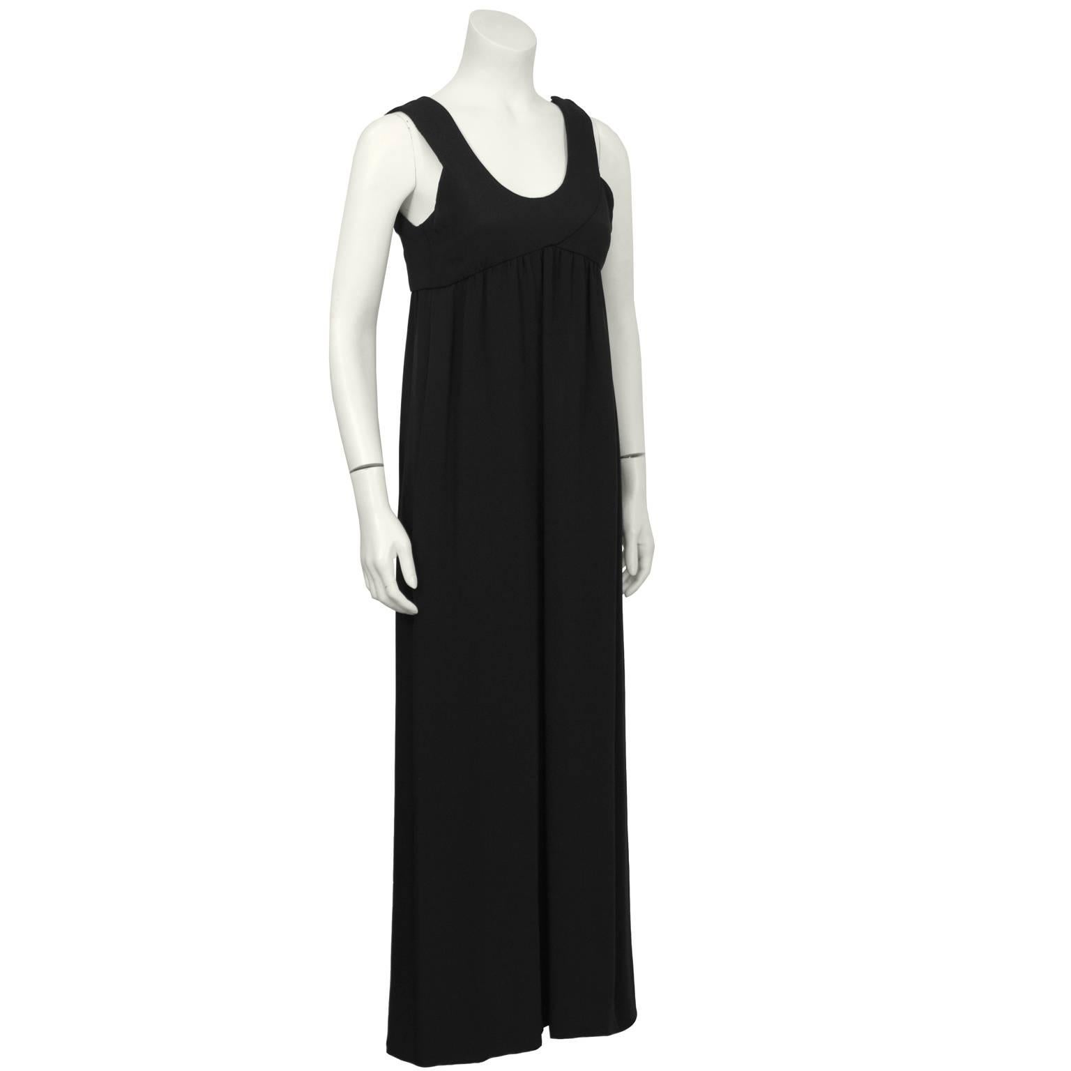 Anonymous black silk empire waist sleeveless gown from the 1970's. The simple dress has a unique bustline with an overlapping detail on the front and the back as well as gathering throughout. The U-neckline and wide shoulder straps are flattering on