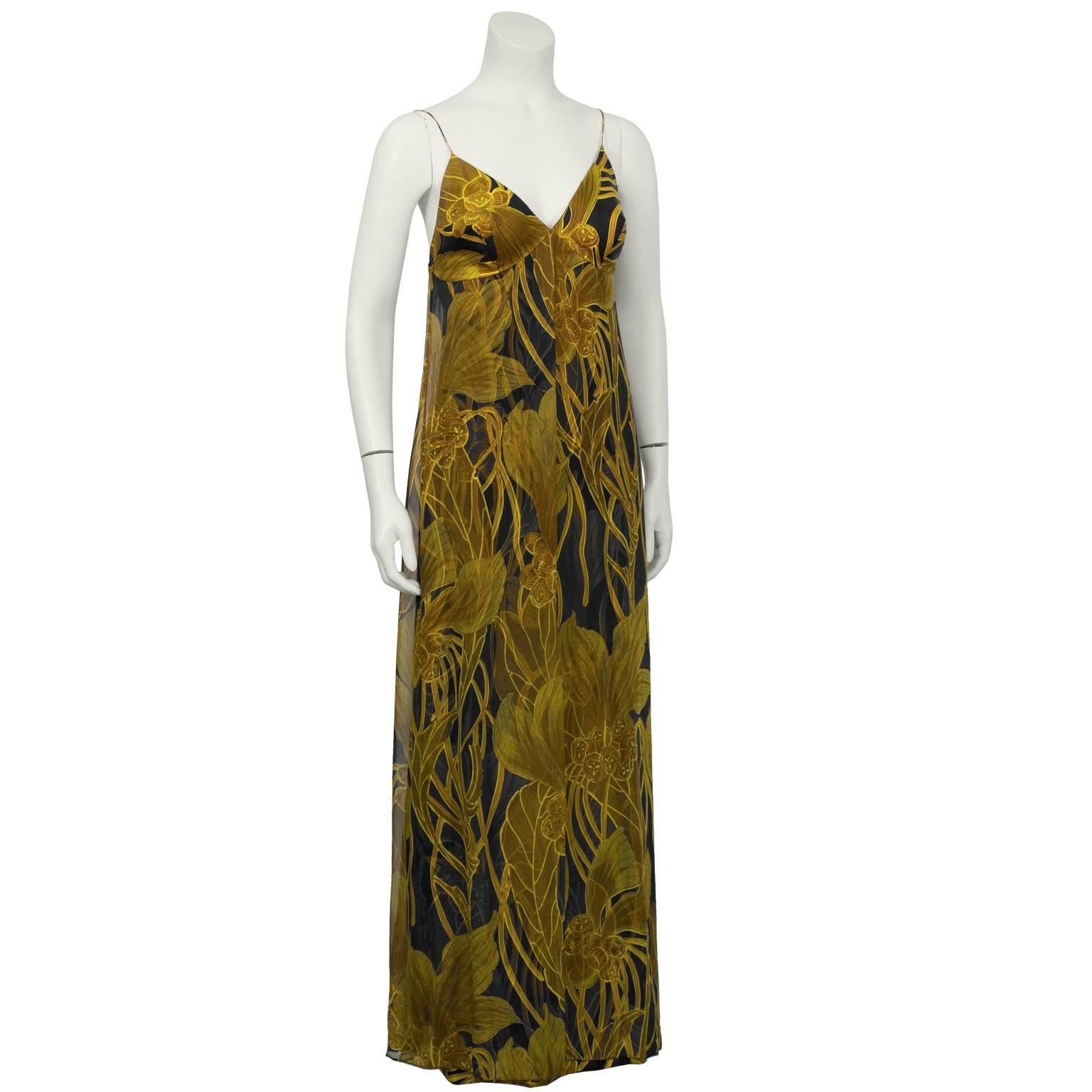 1970's Saks Fifth Ave. brown, gold, and black floral silk and chiffon printed evening gown with matching stole. The spaghetti strap and V-neckline column style gown features a chiffon layer that cascades down from the bustline. The fitted silk