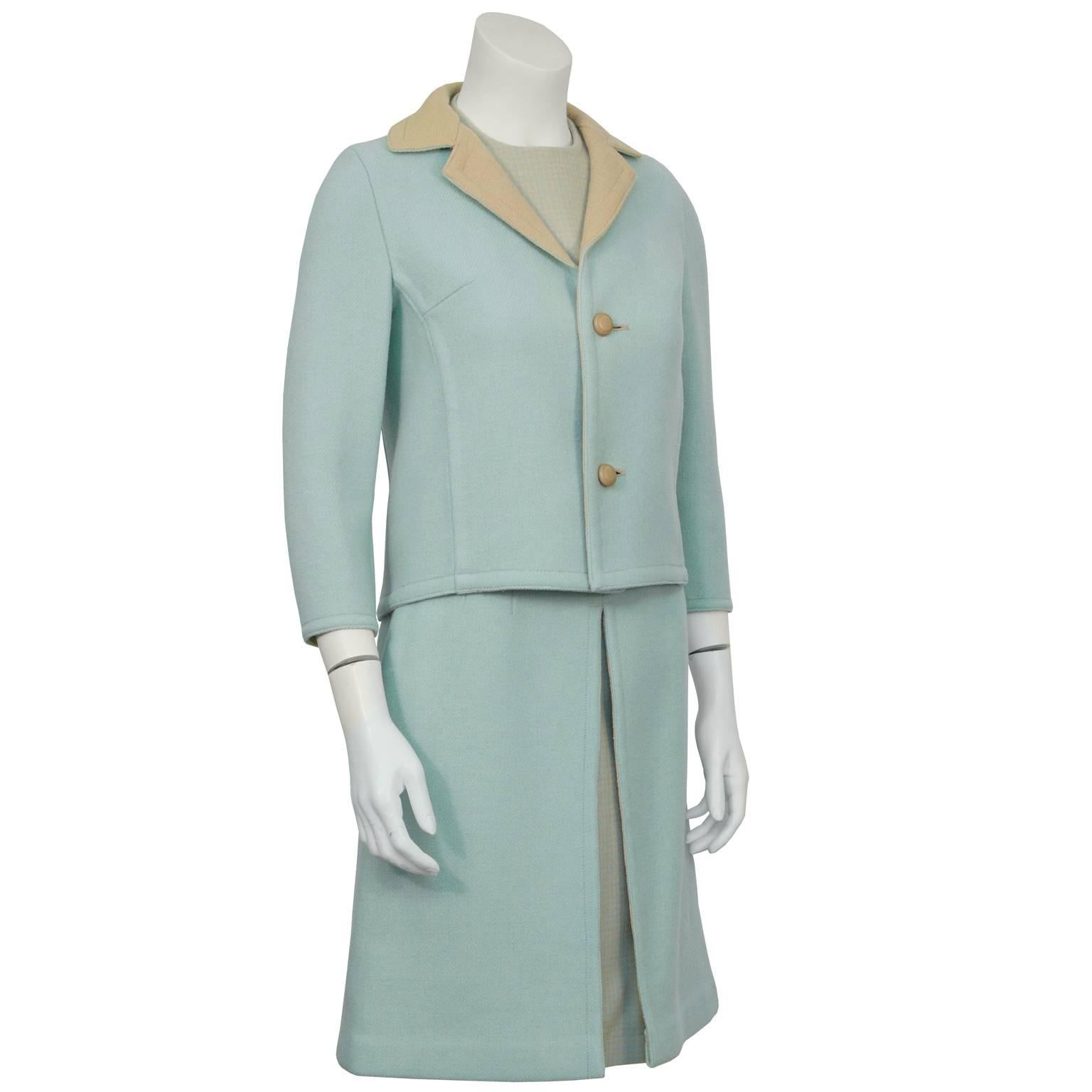 Adorable powder blue and beige double faced wool 3 piece French skirt suit from the 1960's. The jacket is light blue with a beige notched lapel, two round buttons down the front and bracelet length sleeves. The matching shell is made of houndstooth