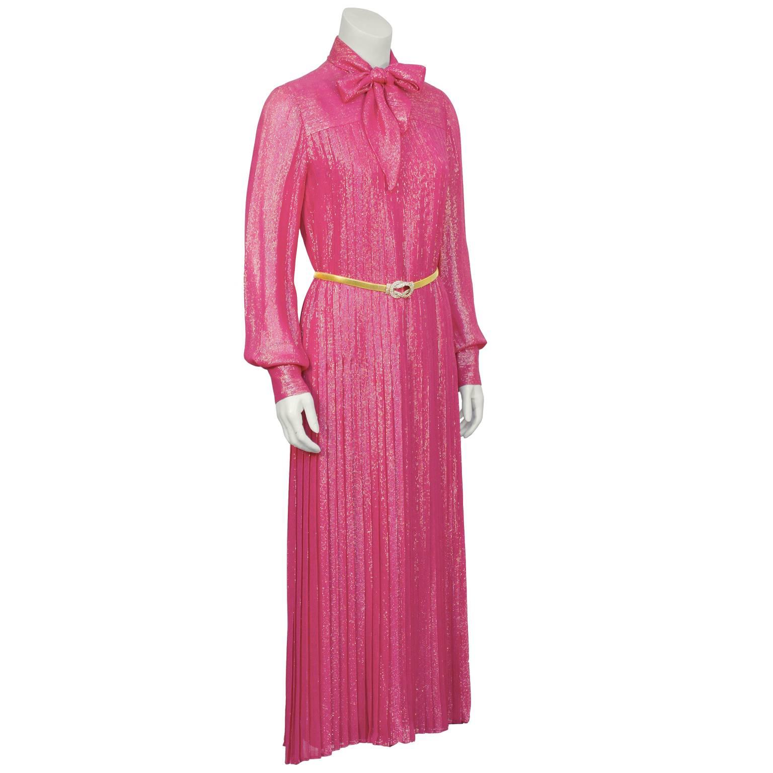 Pink and gold lurex pleated gown by Andre Laug from the 1970's. The long sleeve dress has a round neckline and a yoke seam above the bust. Narrow box pleats travel down the dress with top stitching keeping them in place to the top of the hip.