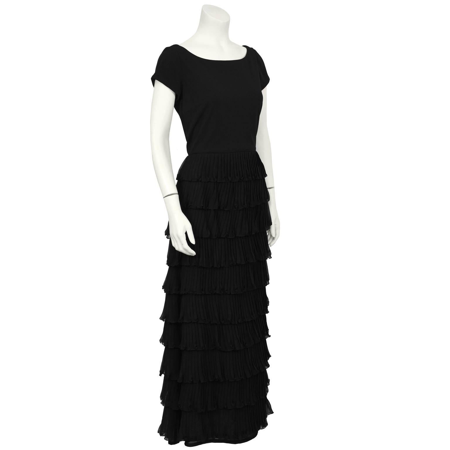 Black chiffon cap sleeved tiered gown from the 1980's. The gown has a scoop neckline and the skirt is made up of tiers of pleated chiffon. Zips up the back, lined in black polyester blend. In excellent condition, fits like a US 6-8. 